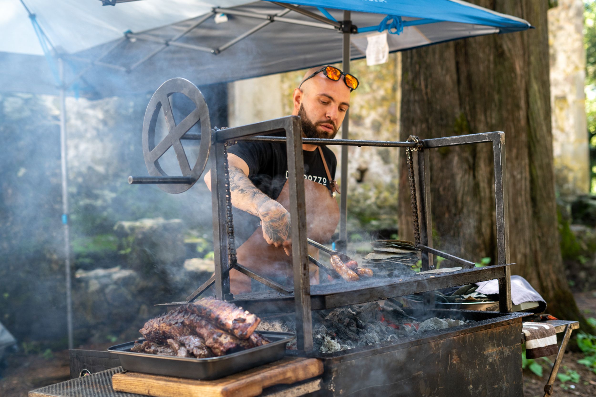Chef tending a smoking outdoor grill
